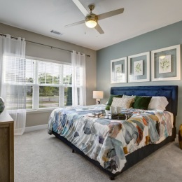 bedroom with bed ceiling fan lamp and windows