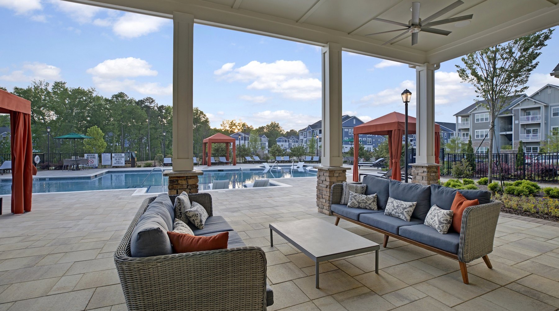 a patio with seating by a pool