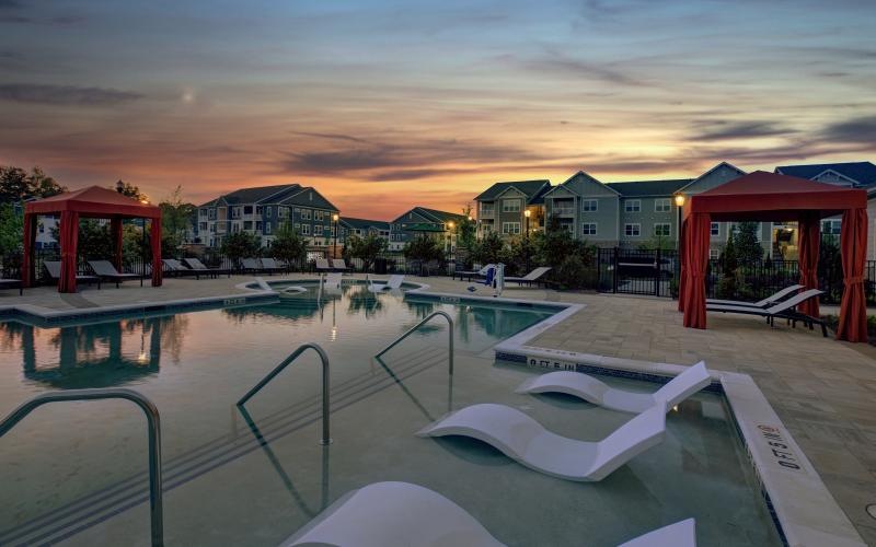 a pool with lounge chairs and a red gazebo