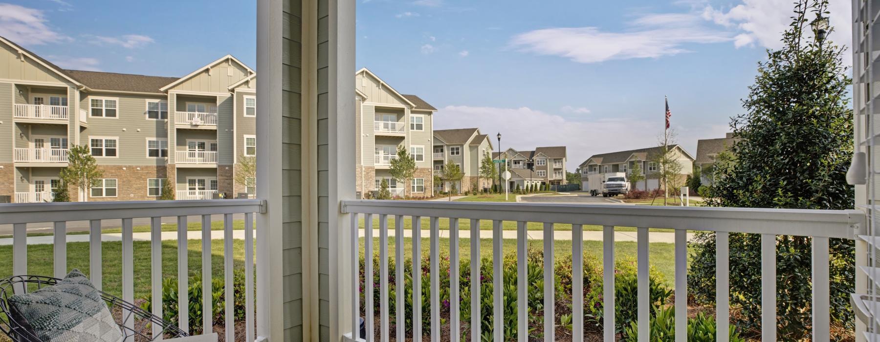 a patio with a railing with buildings in the background