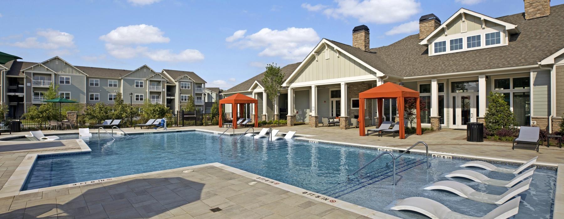 a swimming pool with a row of houses in the background